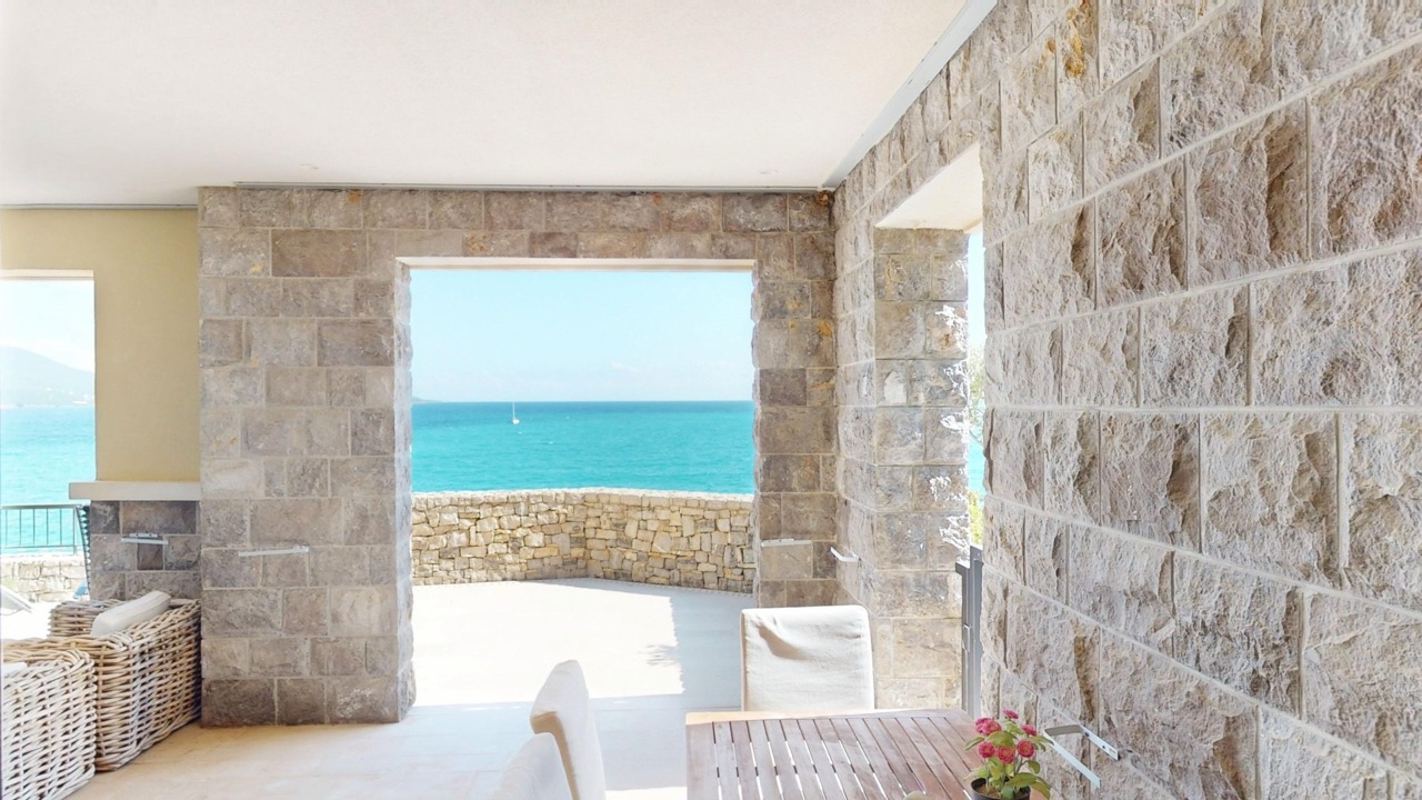 Terrasse mit Steinverkleidung und Meerblick in der Wohnung Lustica Bay, Radovici, Montenegro.