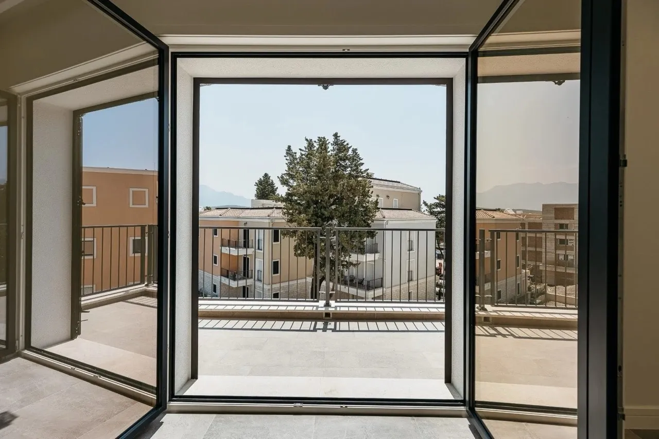 Blick von der großzügigen Terrasse der Wohnung in Luštica Bay, Radovići, Montenegro: Panoramafenster und moderne Architektur.