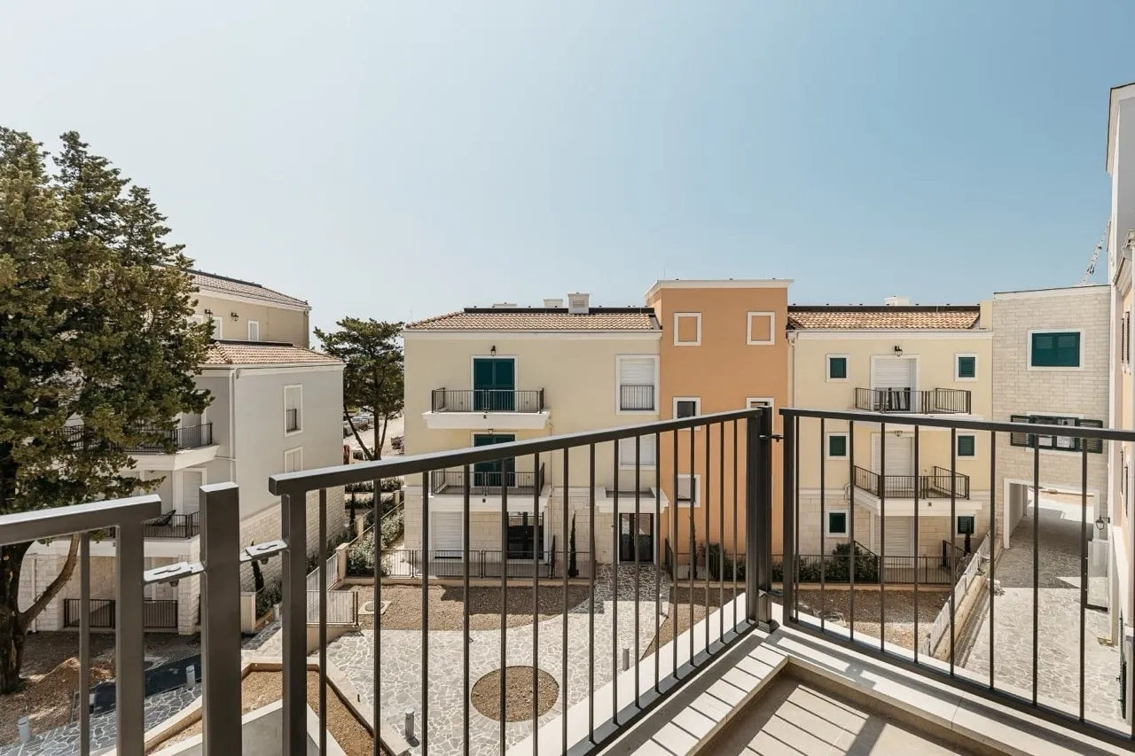 Blick vom Balkon auf den modernen Wohnkomplex in Luštica Bay, Radovići, Montenegro: helle Fassaden und gepflegte Außenanlagen.