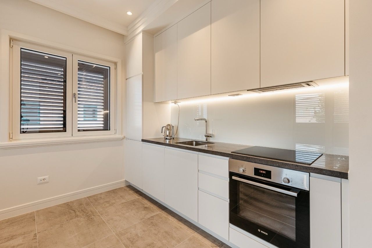 Cuisine blanche moderne avec électroménager Bosch dans un appartement à Luštica Bay, Radovići, Monténégro.