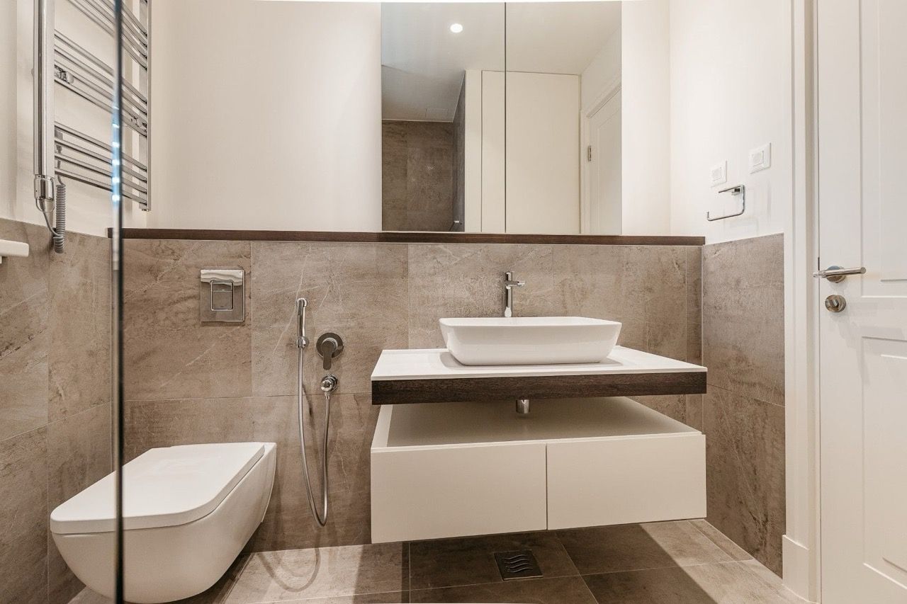 Salle de bains moderne dans un appartement à Luštica Bay, Radovići, Monténégro : sanitaires suspendus et finition en pierre.