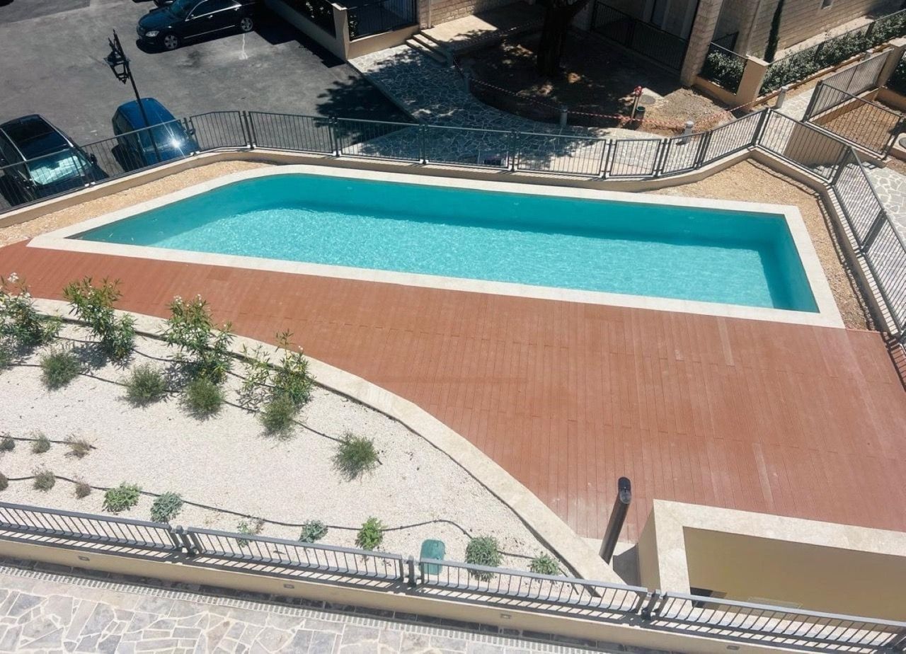 Vue d’en haut sur une piscine extérieure avec terrasse en bois dans le complexe résidentiel Luštica Bay, Radovići, Monténégro.