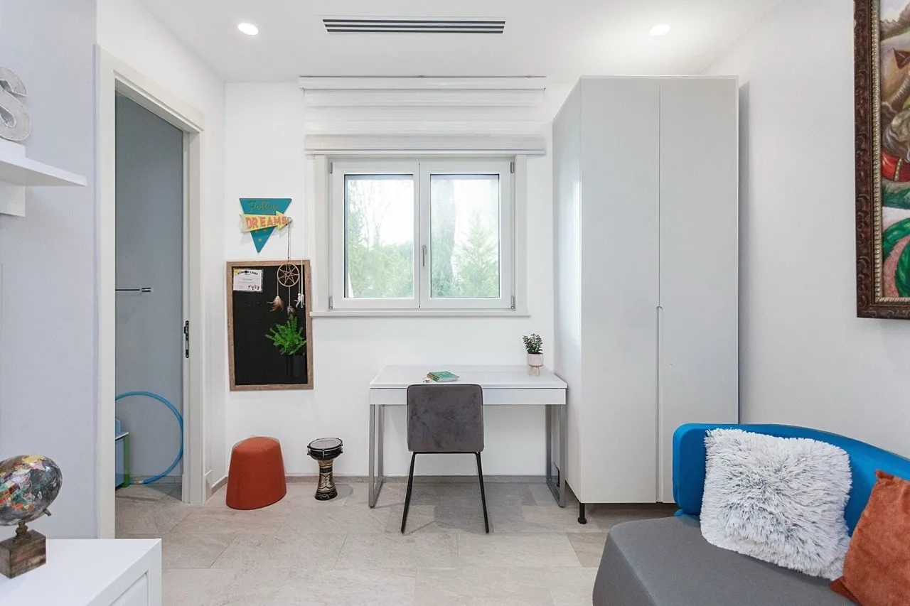 Modernes Schlafzimmer mit Schreibtisch und Kleiderschrank in einer Villa in Luštica Bay, Radovići, Montenegro.