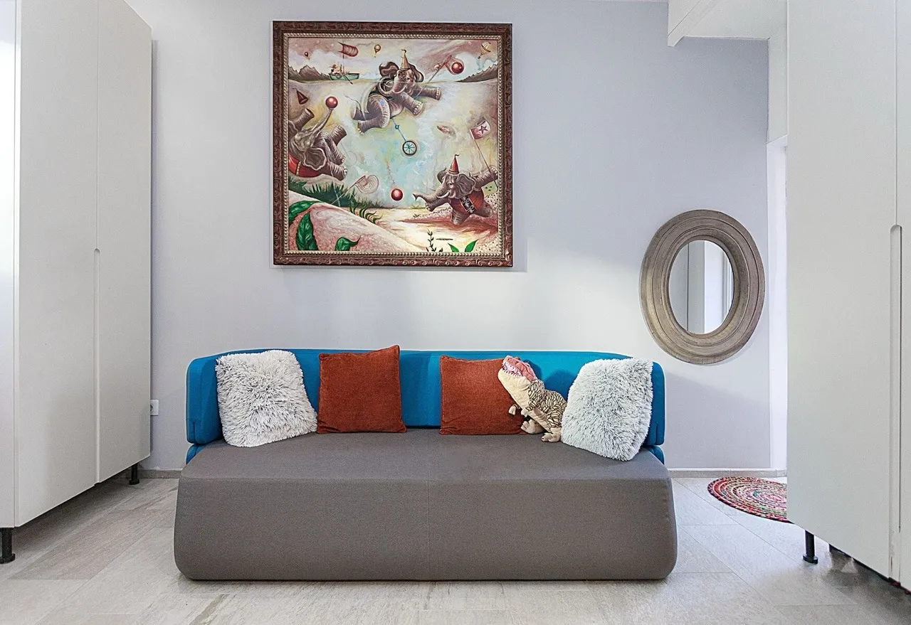 Modernes Wohnzimmer mit blauem Sofa und Gemälde in einer Villa in Luštica Bay, Radovići, Montenegro.