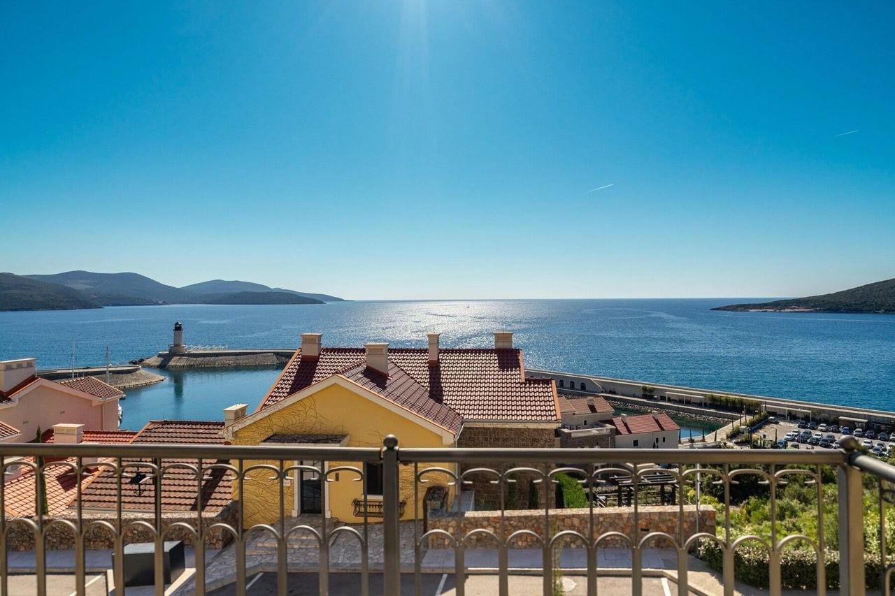 Pogled sa balkona vile u Luštica Bay, Radovići, Crna Gora: panorama mora, svetionika i mediteranskih kuća.