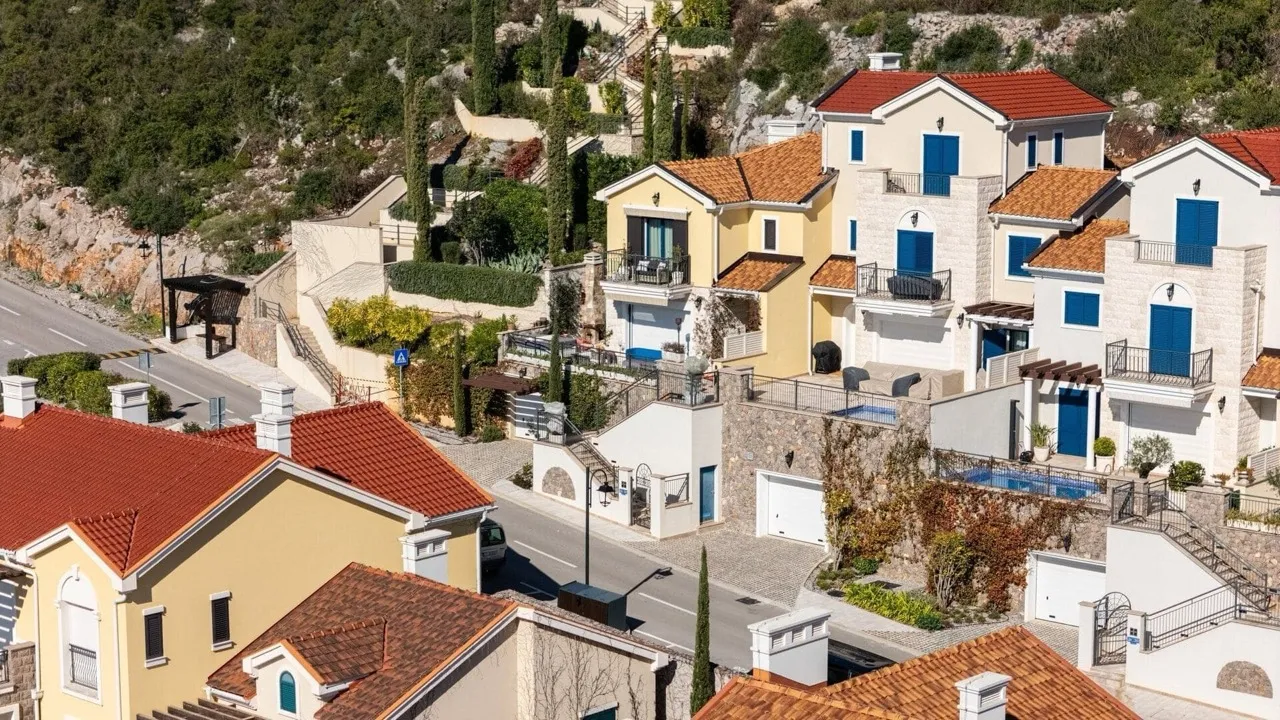 Blick auf moderne Villen mit Ziegeldächern in der exklusiven Anlage Luštica Bay, Radovići, Montenegro.