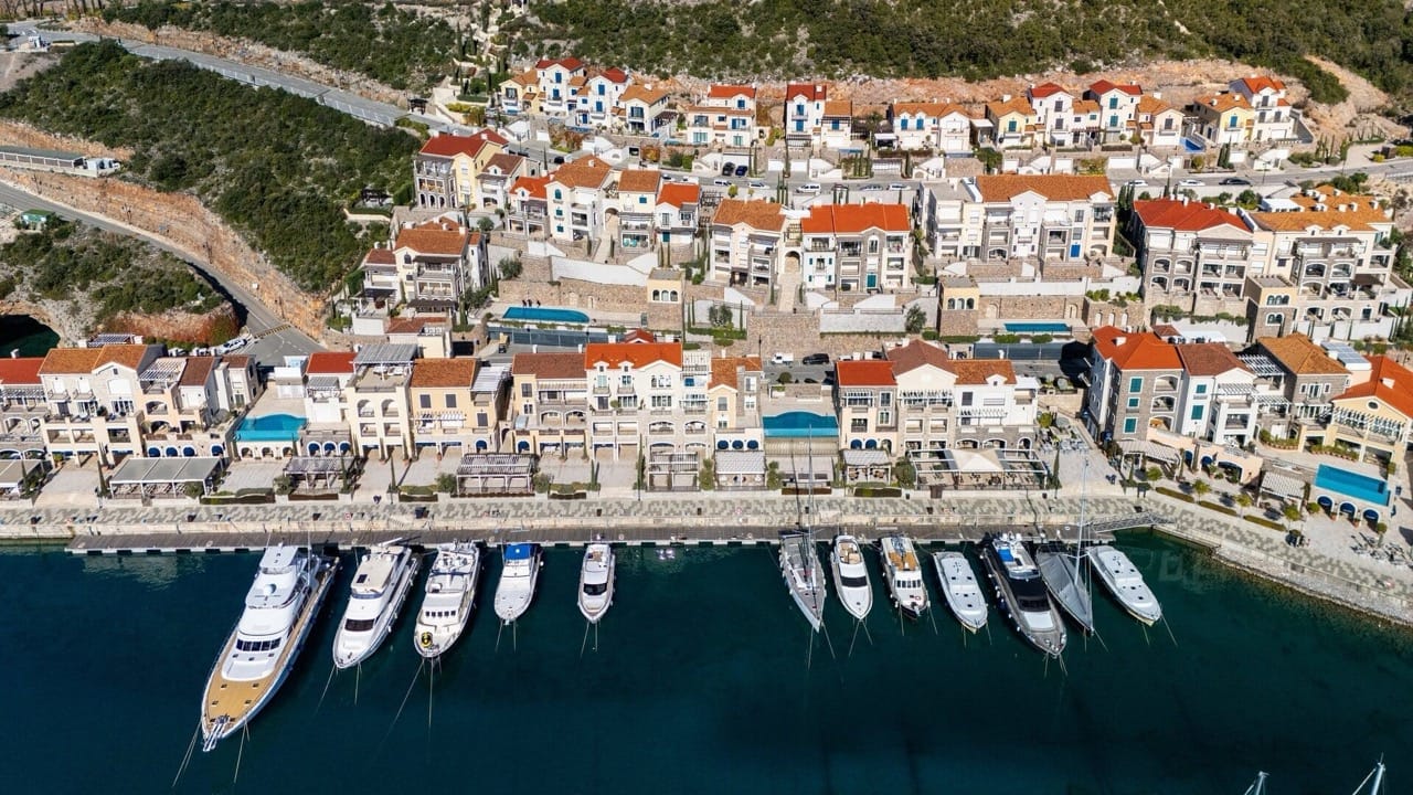 Pogled iz vazduha na elitni kompleks Luštica Bay u Radovićima, Crna Gora: obala sa jahtama i stambene vile.