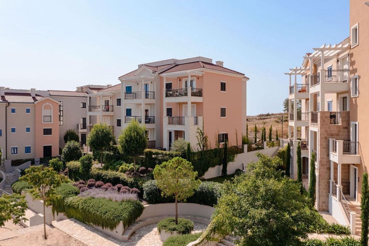 Complexe résidentiel moderne à Luštica Bay, Radovići, Monténégro : immeubles de faible hauteur avec terrasses et jardin bien entretenu.