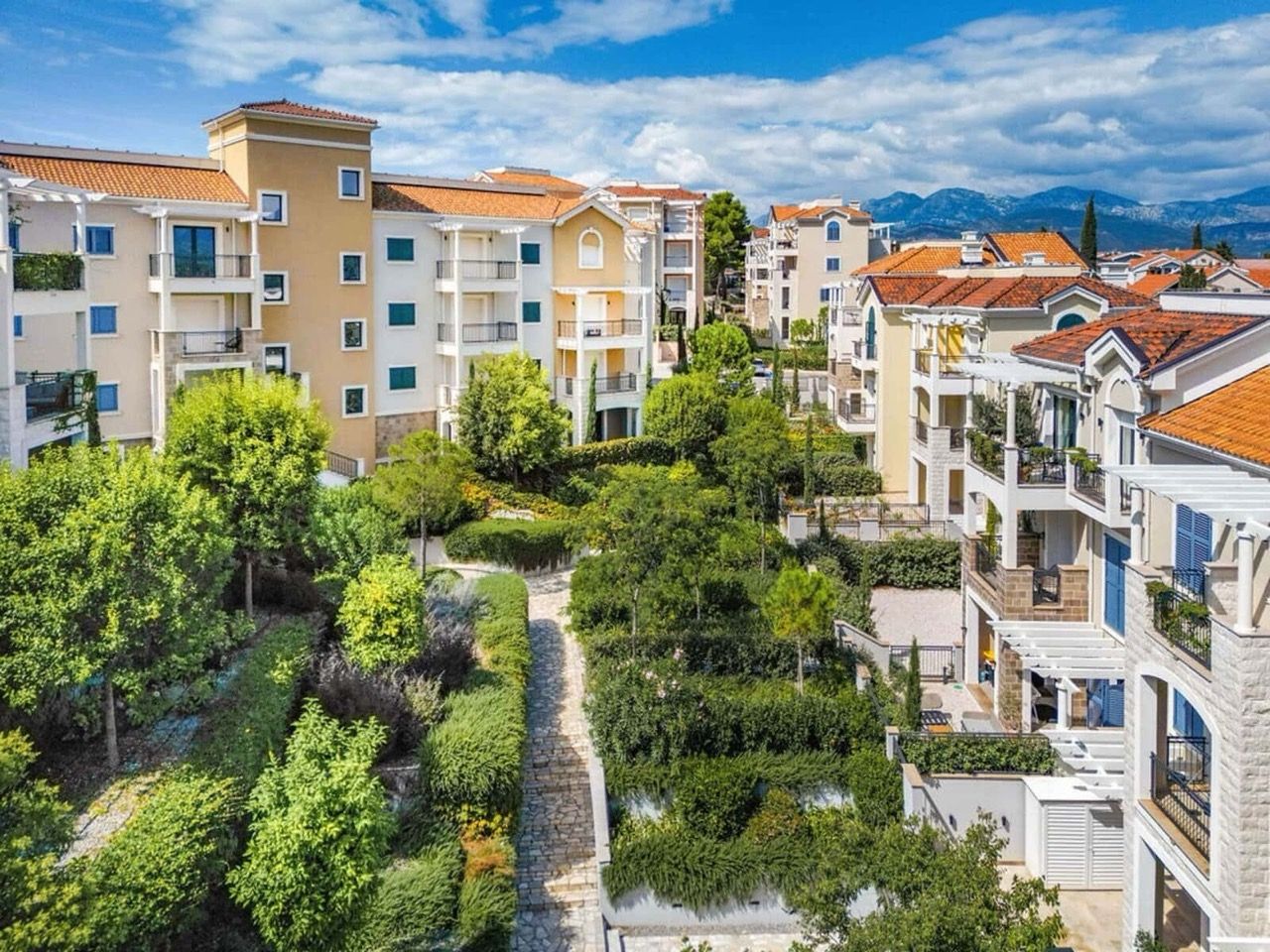 Complexe résidentiel Lustica Bay à Radovici, Monténégro : maisons modernes avec terrasses et jardin verdoyant bien entretenu.