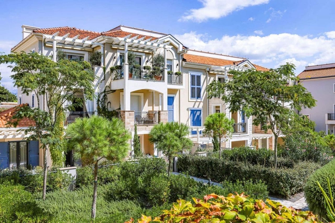 Façade du complexe résidentiel de luxe Lustica Bay à Radovici, Monténégro : terrasses, style méditerranéen et jardin verdoyant.