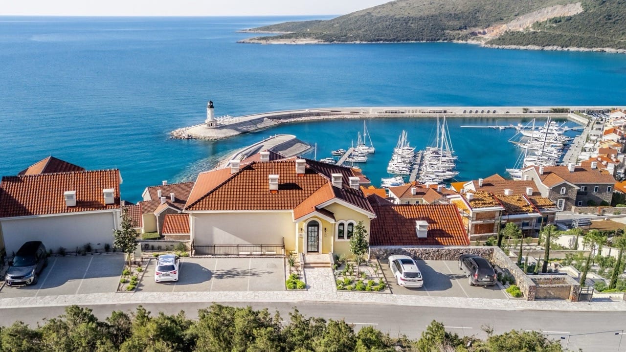 Vue aérienne de villas de luxe à Luštica Bay, Radovići, Monténégro, avec vue panoramique sur la marina et le phare.