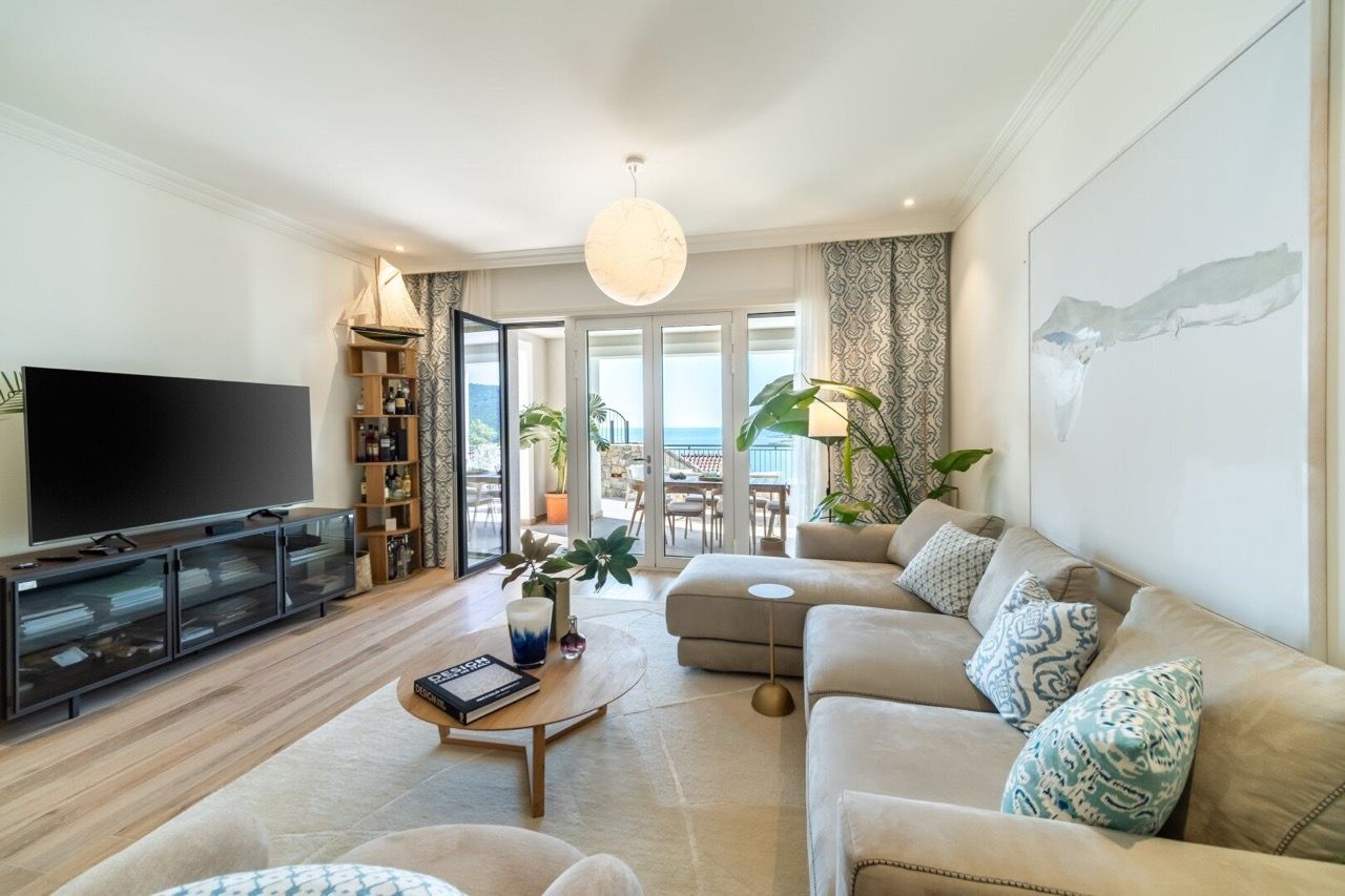 Salon lumineux dans les appartements Luštica Bay, Radovići, Monténégro : canapé moelleux, terrasse avec vue sur la mer et décoration élégante.