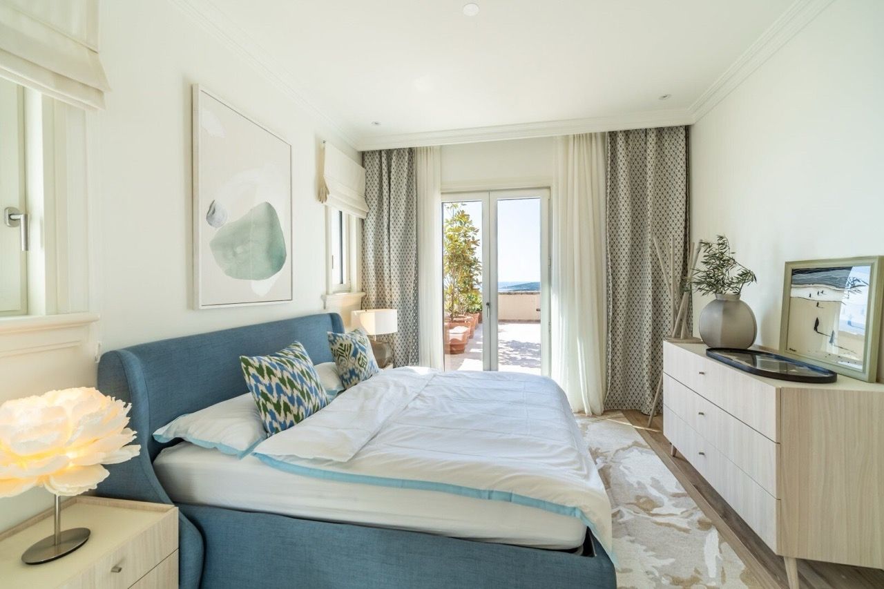 Chambre lumineuse dans les appartements Lustica Bay, Radovici, Monténégro : lit bleu, vue sur la mer et la terrasse.