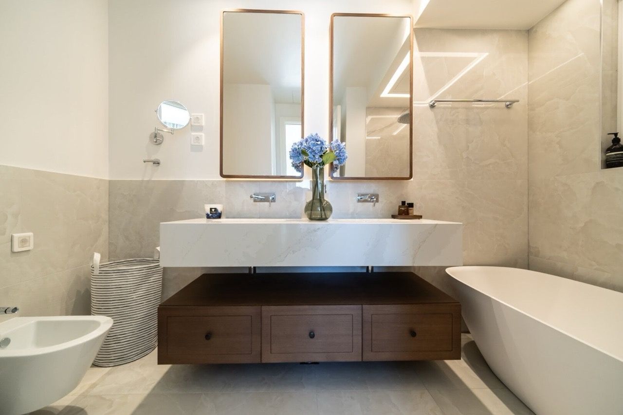 Salle de bains moderne dans un appartement à Luštica Bay, Radovići, Monténégro : plan de travail en marbre et baignoire îlot.