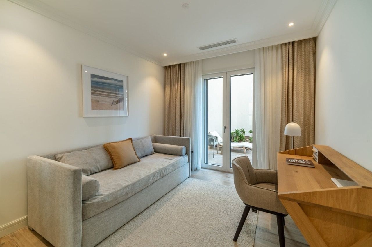 Salon confortable avec canapé et bureau dans l’appartement Lustica Bay, Radovici, Monténégro, accès à la terrasse.