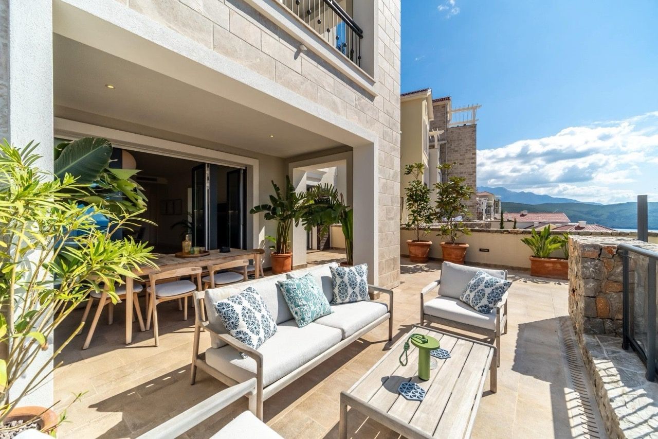 Spacieuse terrasse meublée dans l’appartement à Luštica Bay, Radovići, Monténégro : vue sur les montagnes et finition moderne.