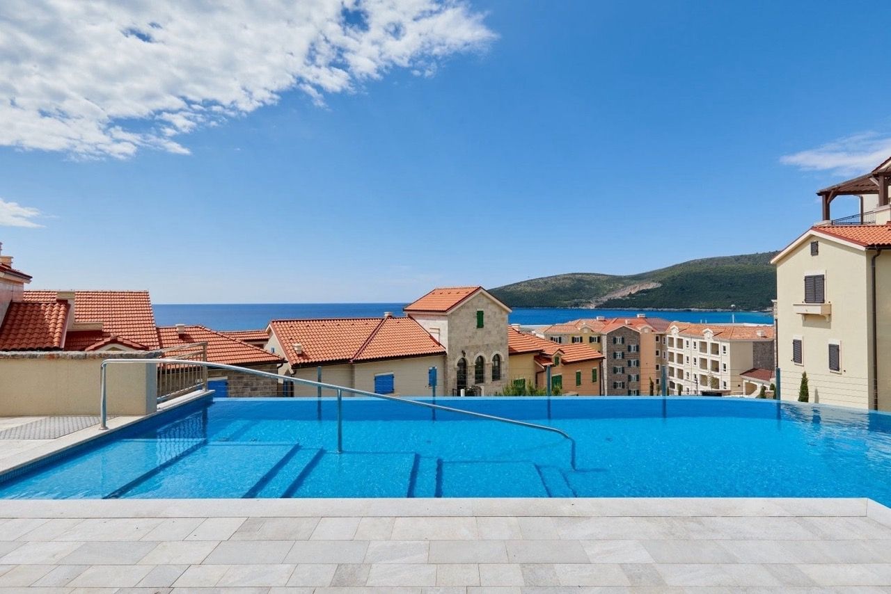 Piscine à débordement extérieure avec vue sur la mer et le complexe résidentiel Luštica Bay à Radovići, Monténégro.