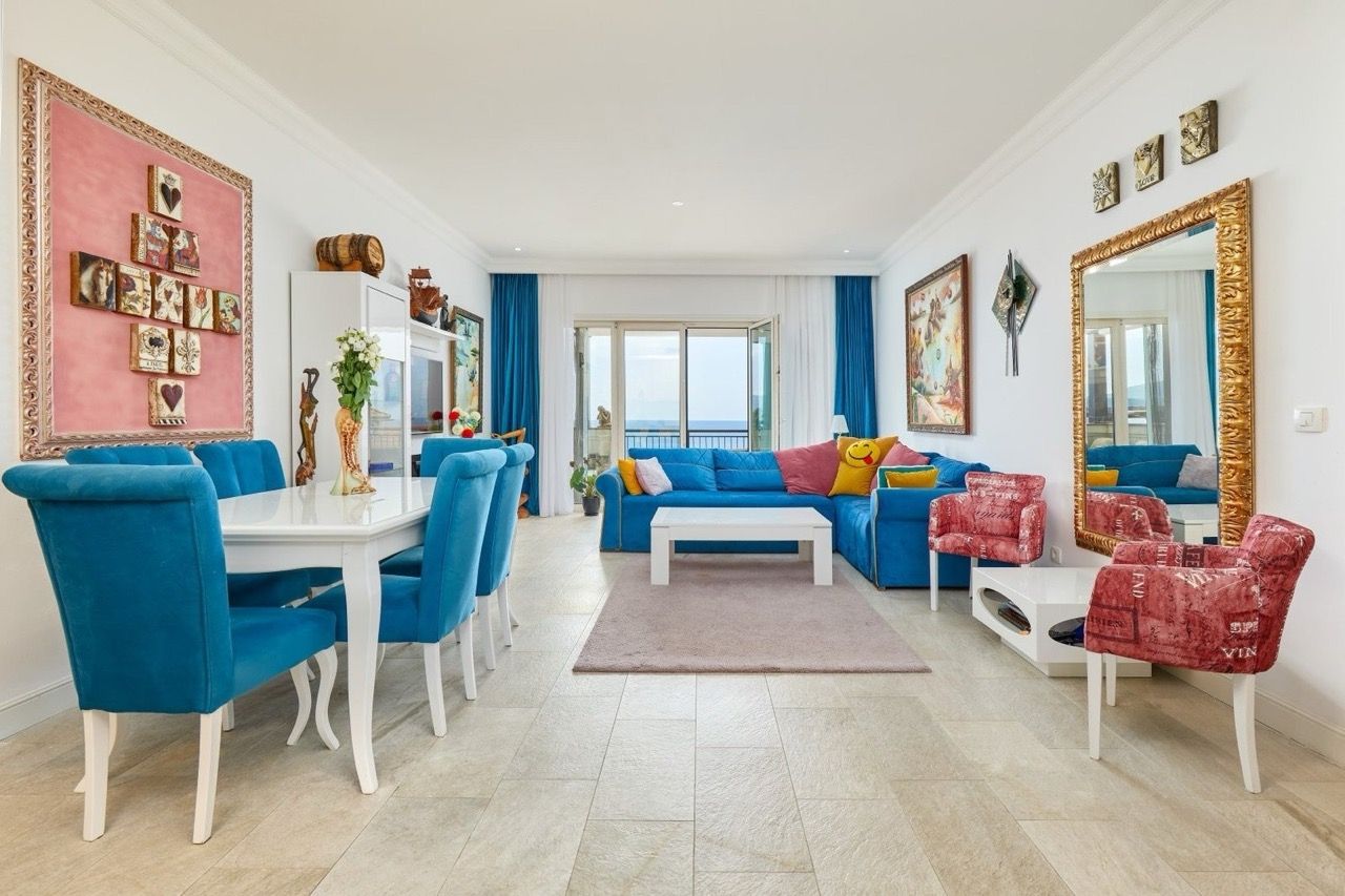 Salon avec mobilier bleu et vue sur la mer dans un appartement, Luštica Bay, Radovići, Monténégro : intérieur élégant avec décoration.