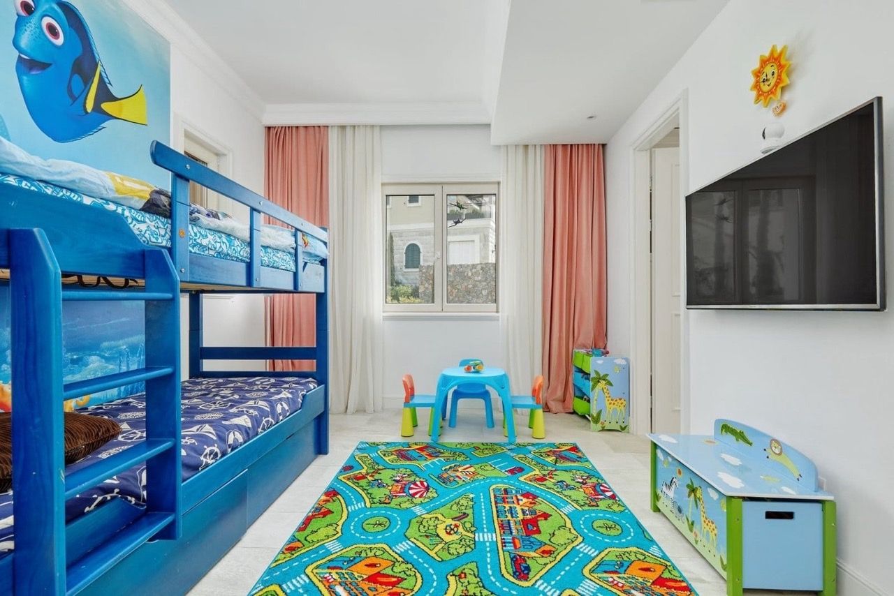 Chambre d’enfant avec lit superposé dans un appartement à Luštica Bay, Radovići, Monténégro : mobilier et décoration colorés.