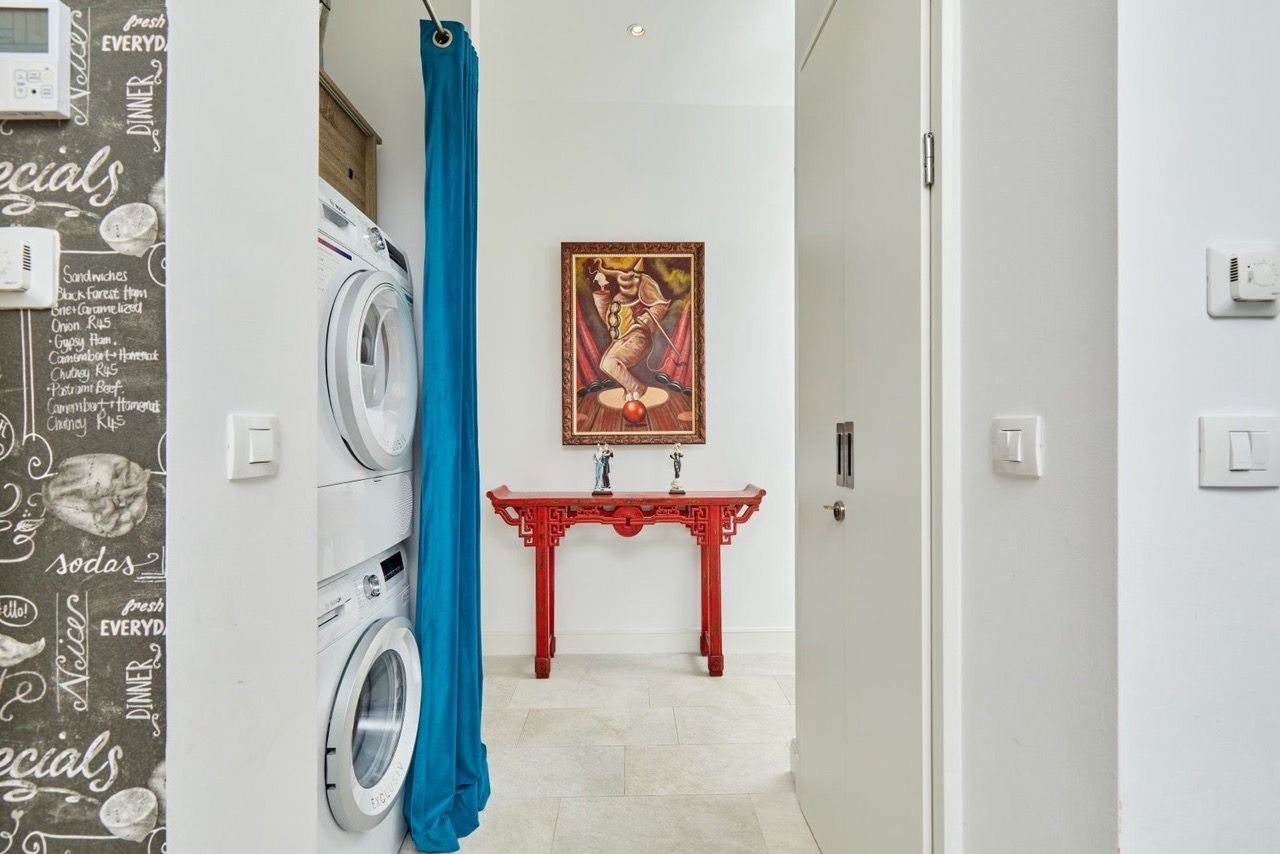 Zone utilitaire avec appareils électroménagers et intérieur élégant dans un appartement à Luštica Bay, Radovići, Monténégro.