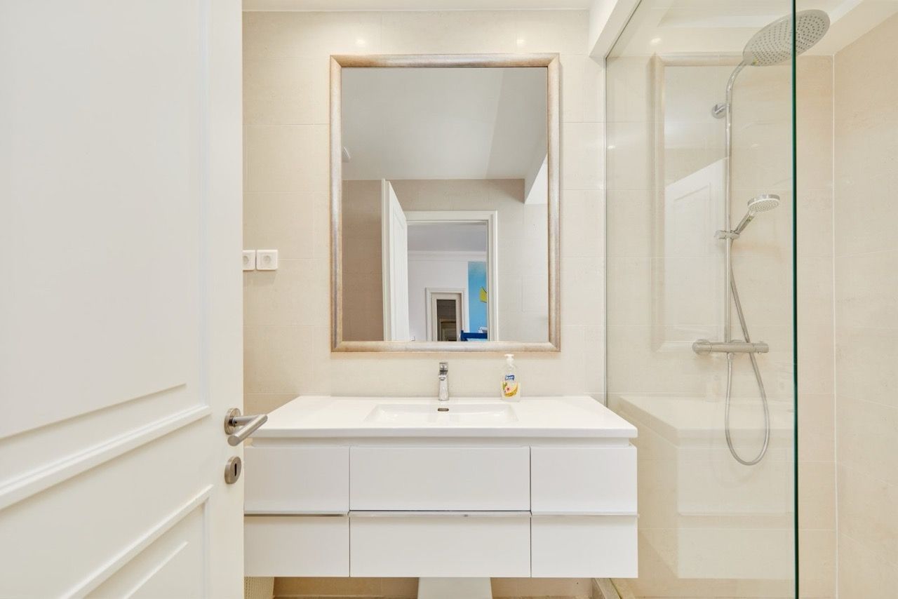 Salle de bains moderne avec cabine de douche dans l’appartement Luštica Bay, Radovići, Monténégro : mobilier blanc et carrelage.