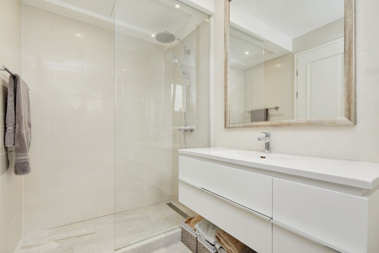 Salle de bains moderne avec cabine de douche et mobilier blanc dans les appartements Luštica Bay, Radovići, Monténégro.