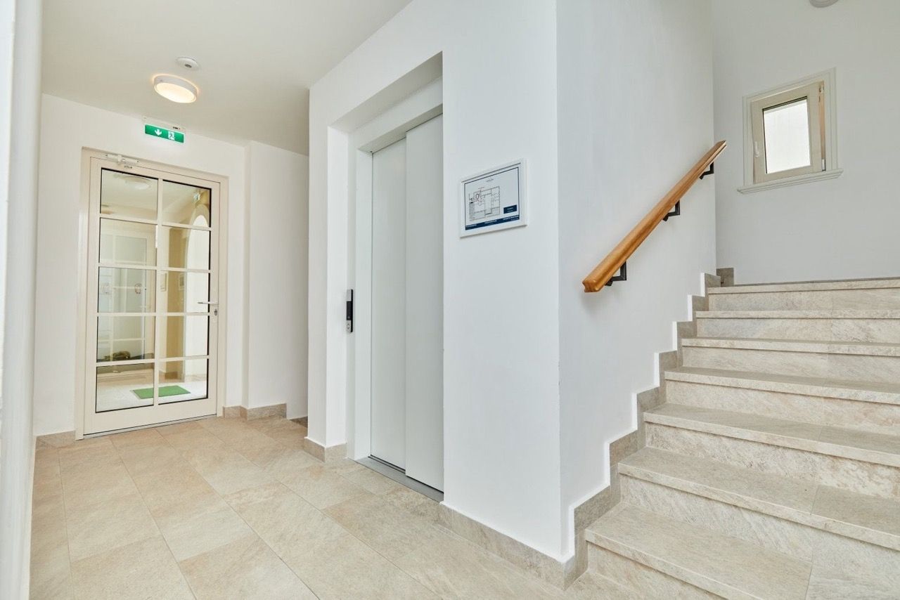 Entrée lumineuse avec ascenseur et escalier en pierre dans le complexe résidentiel Luštica Bay, Radovići, Monténégro.