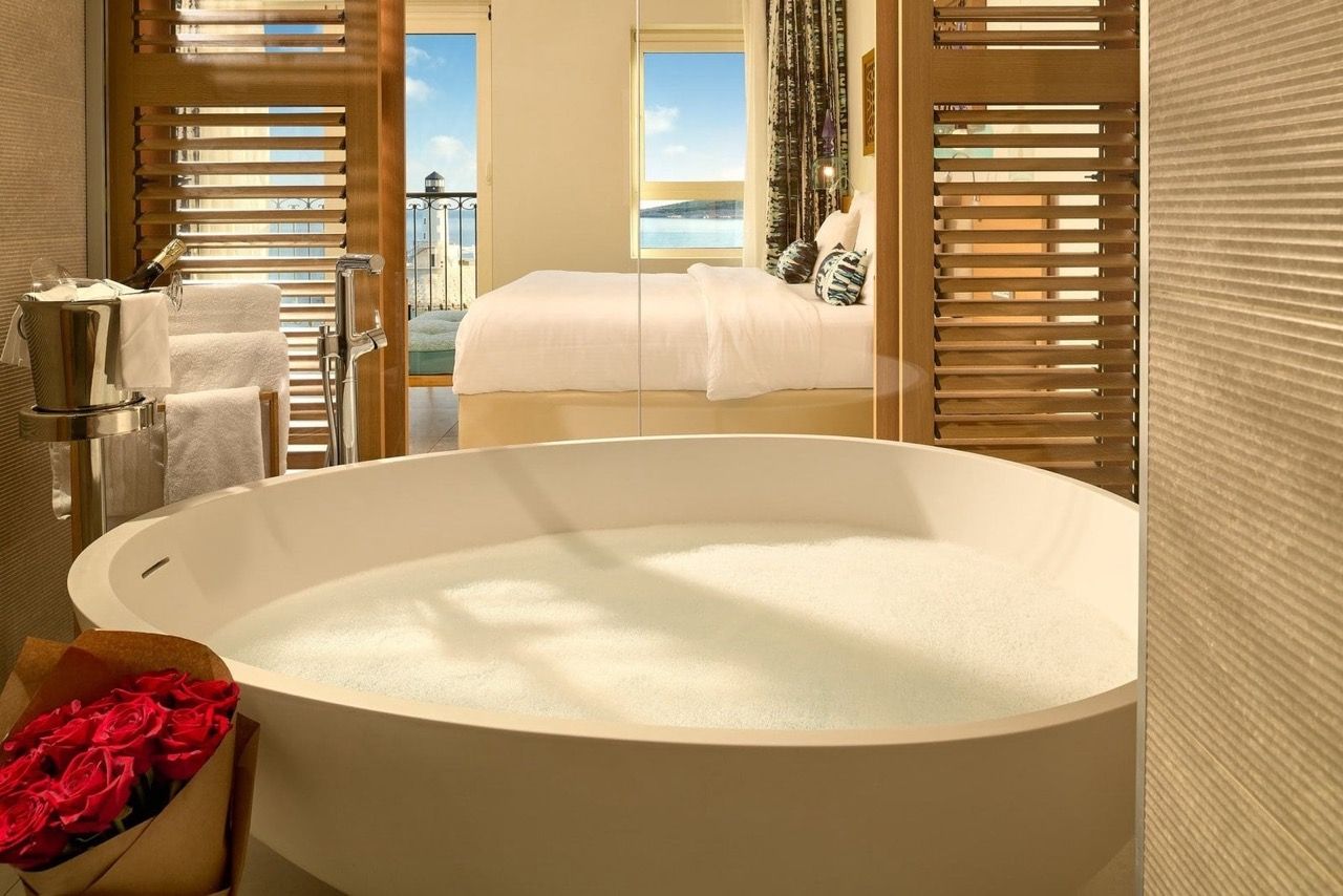 Salle de bains avec baignoire ronde et vue sur la mer dans les appartements Luštica Bay, Radovići, Monténégro.
