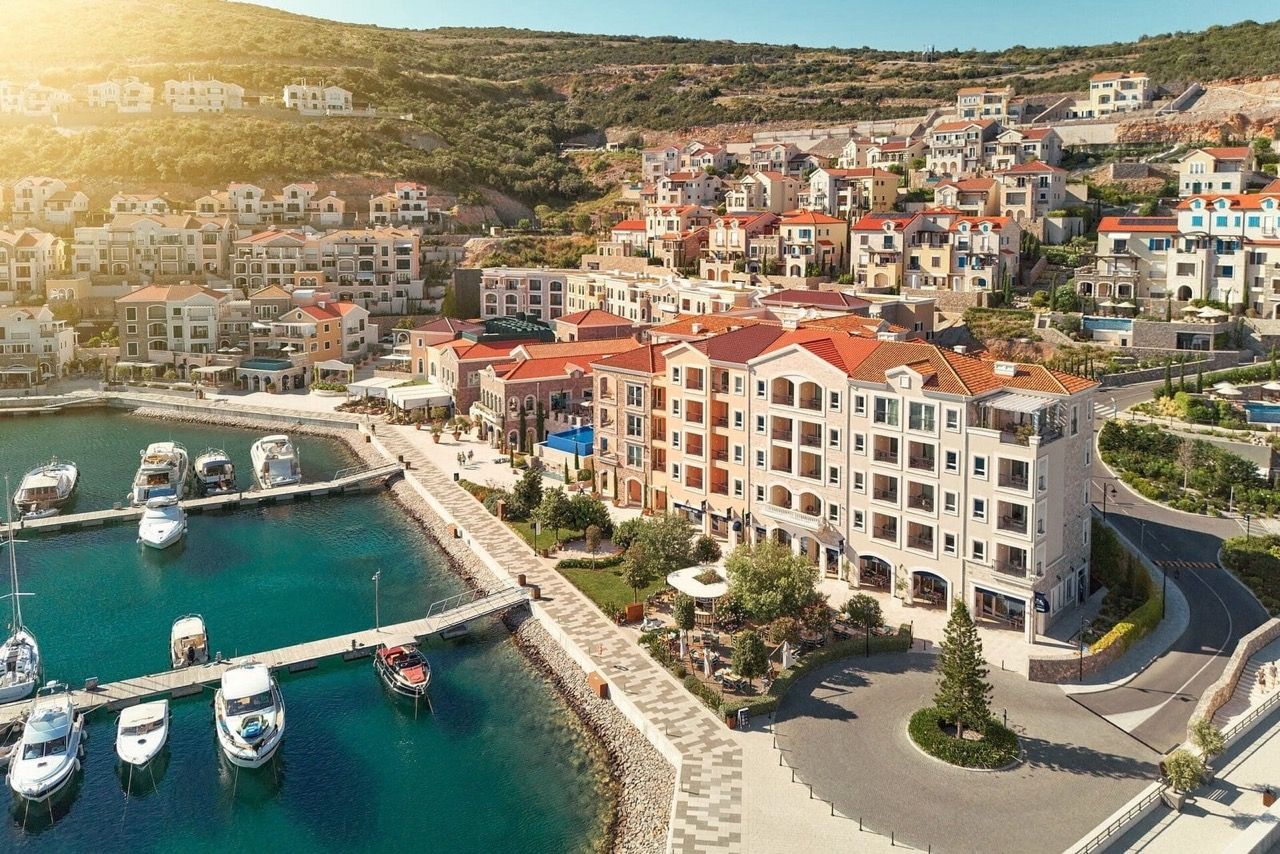Vue aérienne du complexe résidentiel de luxe Lustica Bay à Radovići, Monténégro : promenade, marina de yachts et appartements.