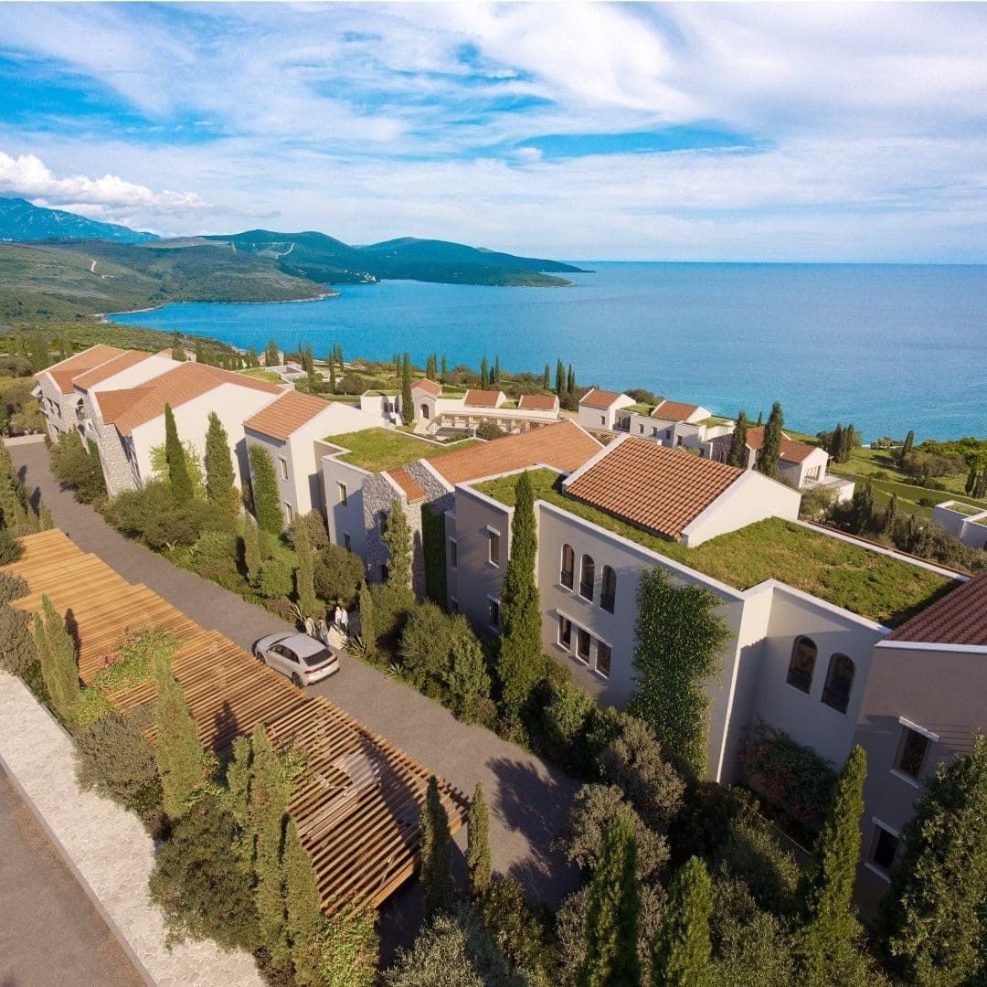 Aerial view of the luxury Lustica Bay residential complex in Radovici, Montenegro: modern villas with green roofs.