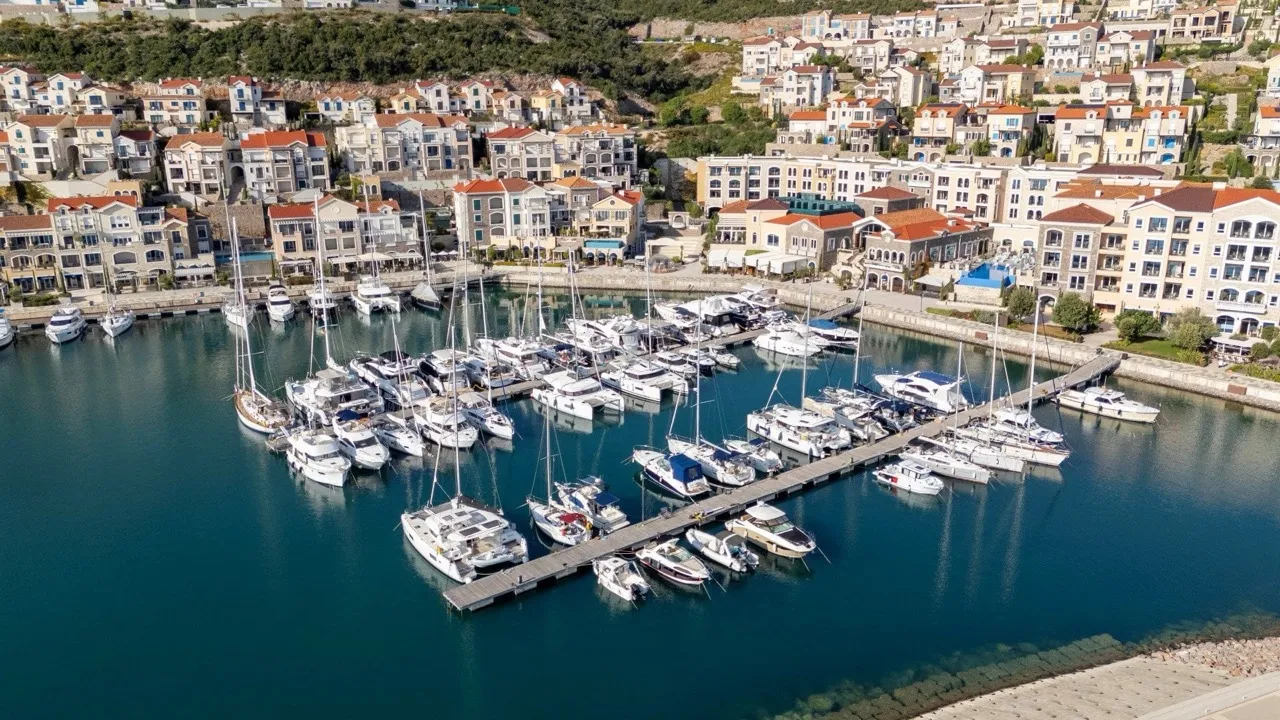 Luftaufnahme der Marina und der exklusiven Wohnanlage Lustica Bay in Radovici, Montenegro, mit angelegten Yachten.