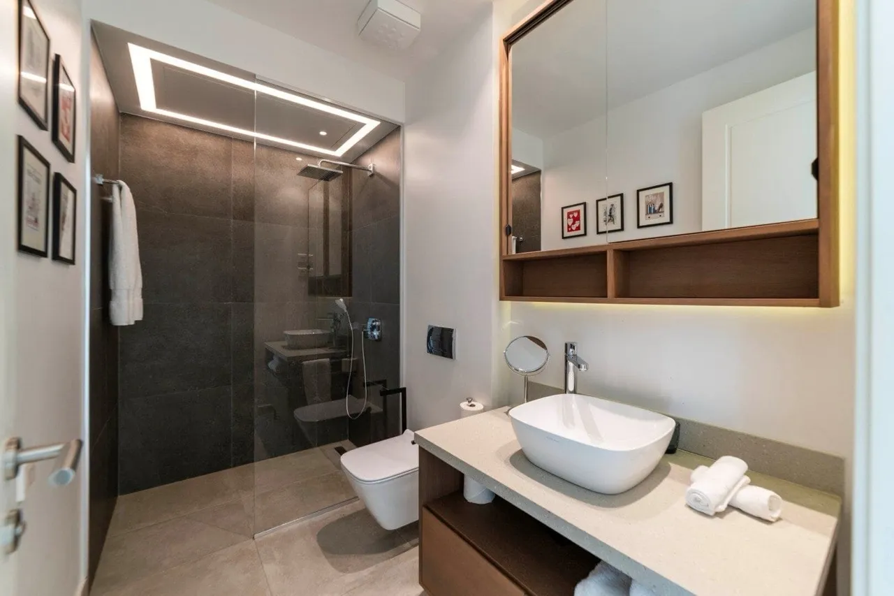 Modernes Badezimmer in einer Wohnung in Luštica Bay, Radovići, Montenegro: Duschkabine, stilvolle Sanitäranlagen und Dekor.