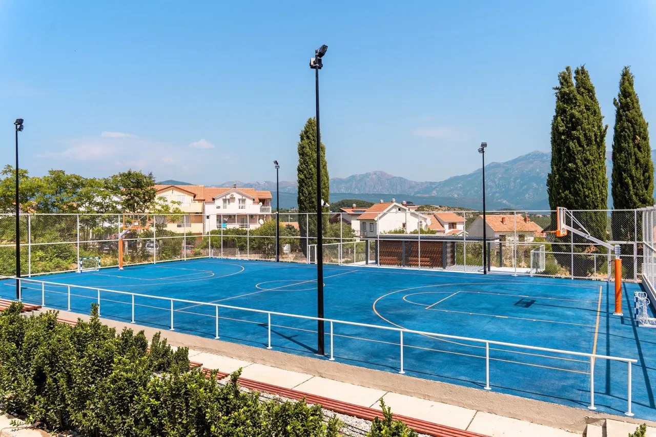 Multifunktionaler Sportplatz mit blauem Belag im Wohnkomplex Luštica Bay, Radovići, Montenegro.