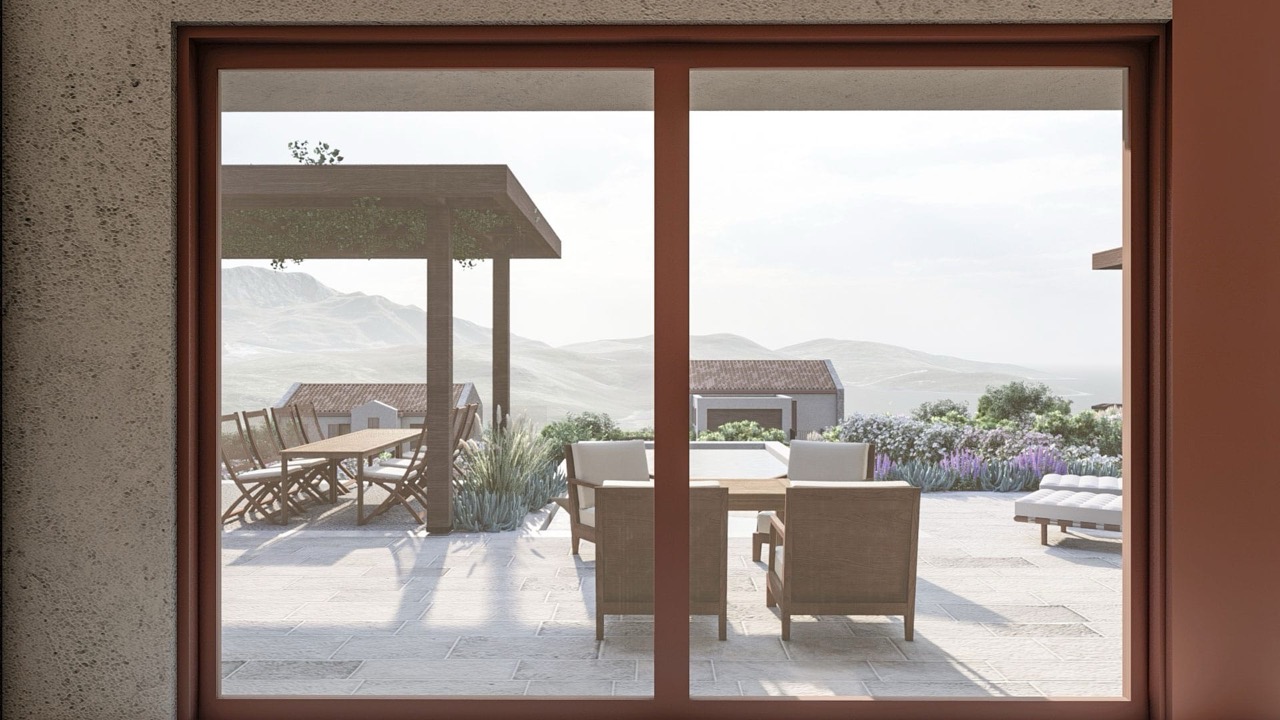 Blick von der Terrasse der Villa in Luštica Bay, Montenegro: Essbereich, Liegestühle und Panoramablick auf Berge und Meer.