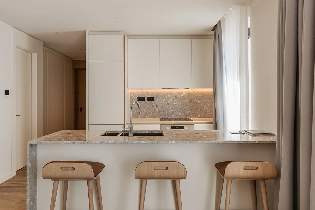Moderne Küche mit Kochinsel und Barhockern in einer Wohnung im ЖК Porto Montenegro, Tivat, Montenegro.