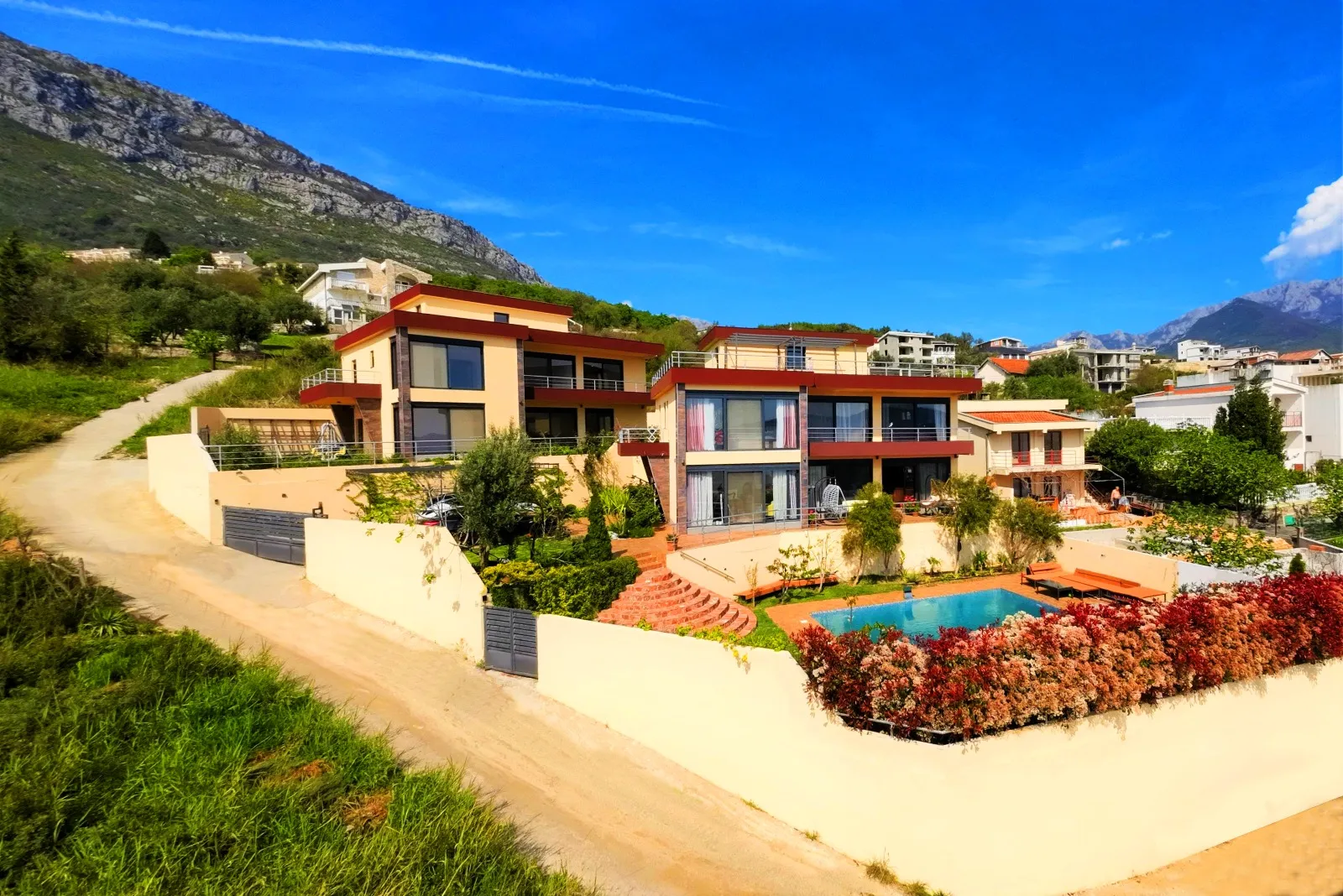 Moderne Villa in Bar, Montenegro: zweistöckiges Haus mit Panoramafenstern, Pool und Landschaftsgestaltung.