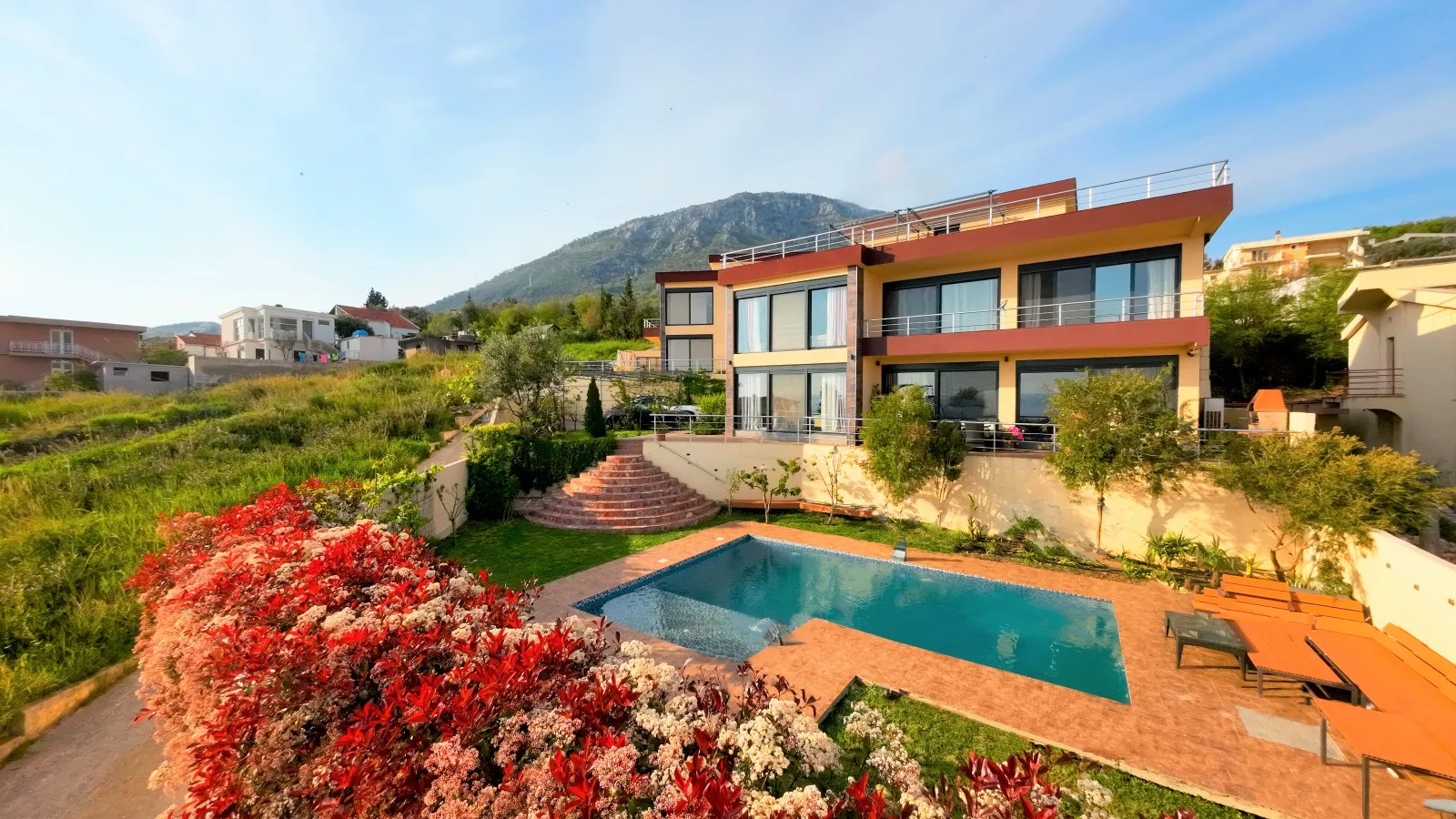 Moderne Villa in Bar, Montenegro: Pool, Terrasse mit Sonnenliegen, Landschaftsgestaltung und Bergblick.