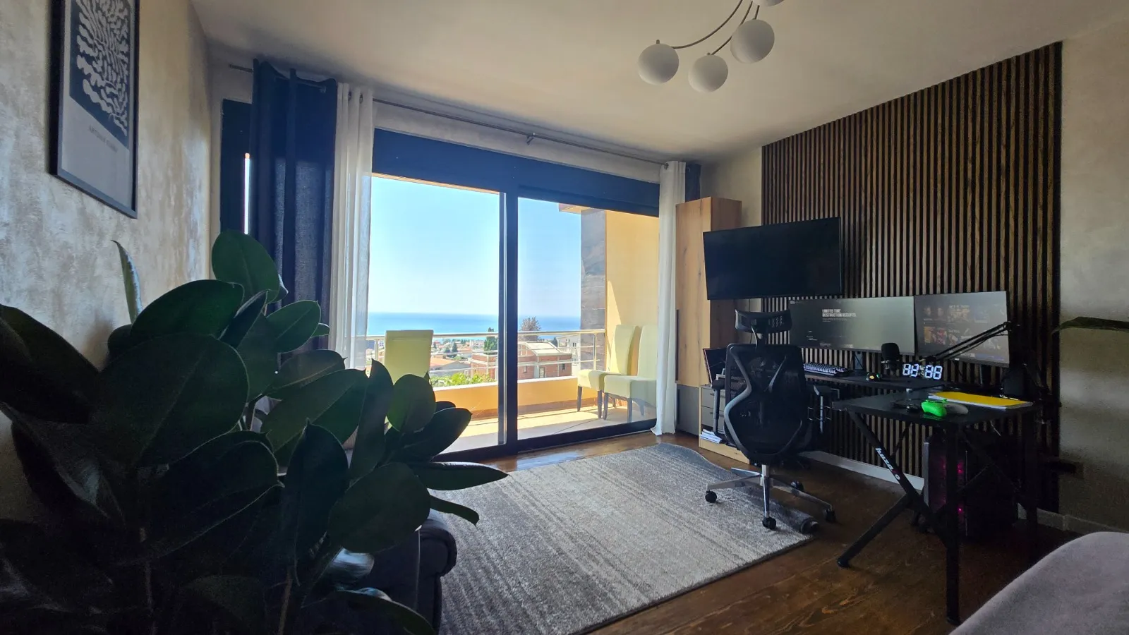 Wohnzimmer mit Arbeitsplatz und Panoramablick auf das Meer in einer Villa, Stadt Bar, Montenegro: stilvolle Verkleidung mit Holzleisten.