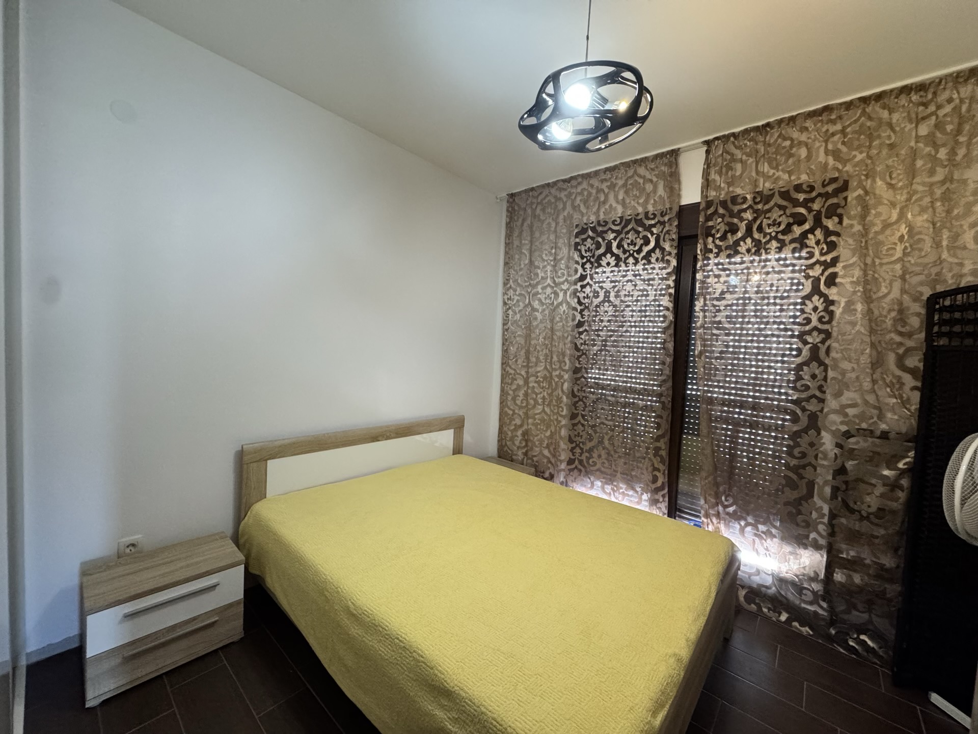 Cozy bedroom with a double bed in an apartment in Budva, Montenegro: modern furniture and panoramic curtains.