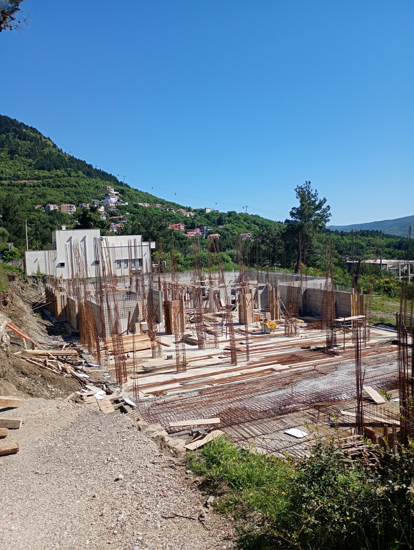 Construction of a residential complex in Budva, Montenegro: foundation rebar frame and mountain view.