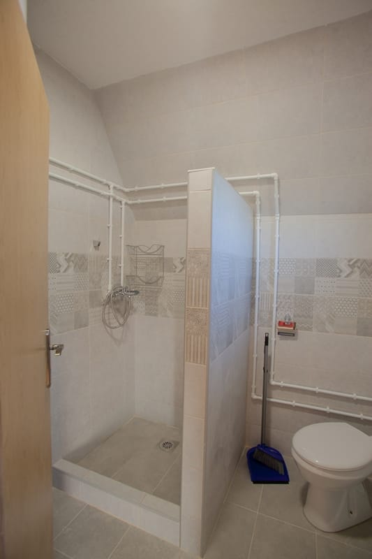 Bathroom with a shower cabin and light-colored tiles in a residential complex, Žabljak, Montenegro.