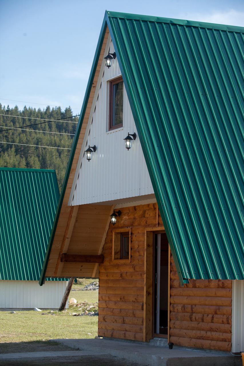 A-frame wooden house with a green roof in a mountain complex, Žabljak, Montenegro.