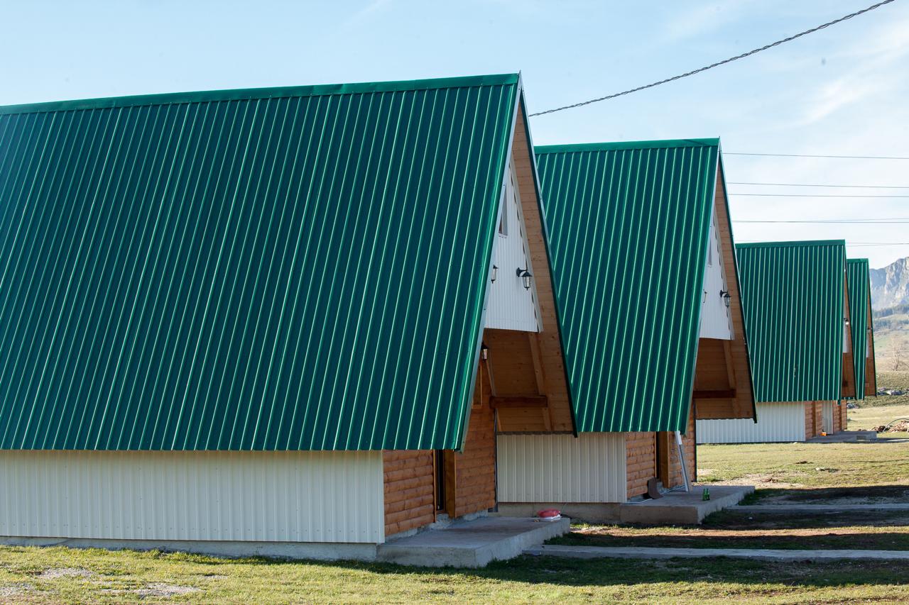 Wooden A-frame houses with green roofs in a mountain complex, Žabljak, Montenegro.