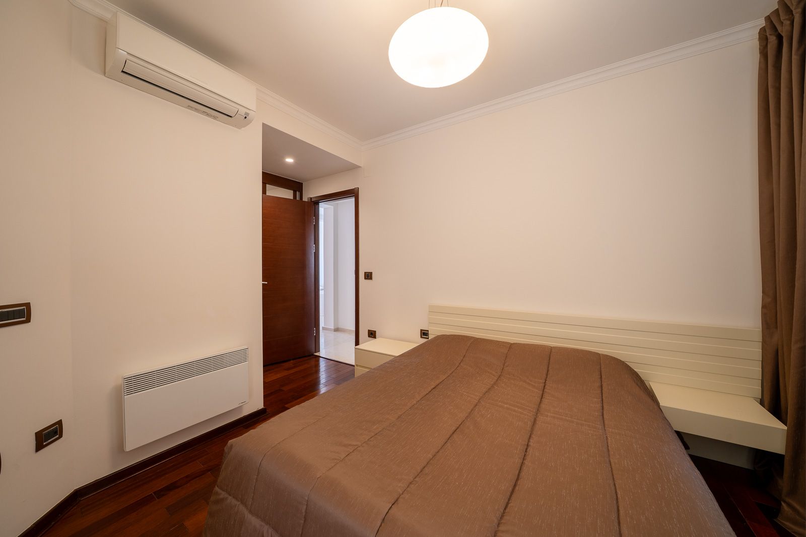 Helles Schlafzimmer mit Doppelbett, Klimaanlage und Parkett in einer Wohnung zum Verkauf in Petrovac, Montenegro.