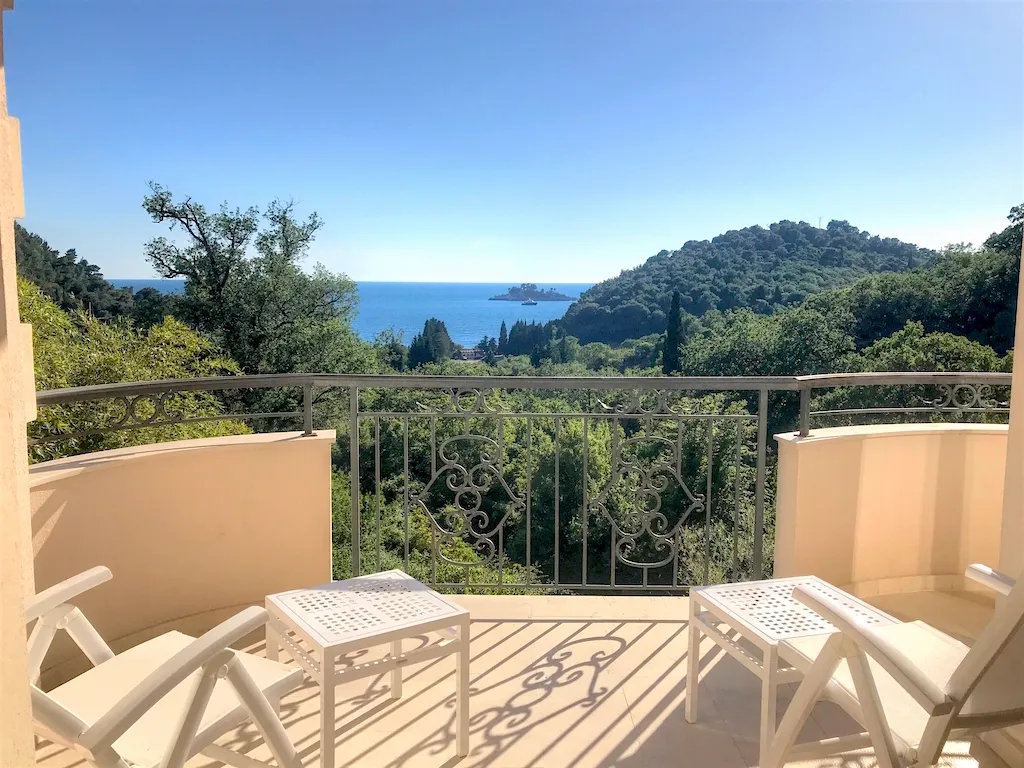 Balkon sa kovanom ogradom i nameštajem u stanu u Petrovcu, Crna Gora, sa panoramskim pogledom na more i zelenilo.
