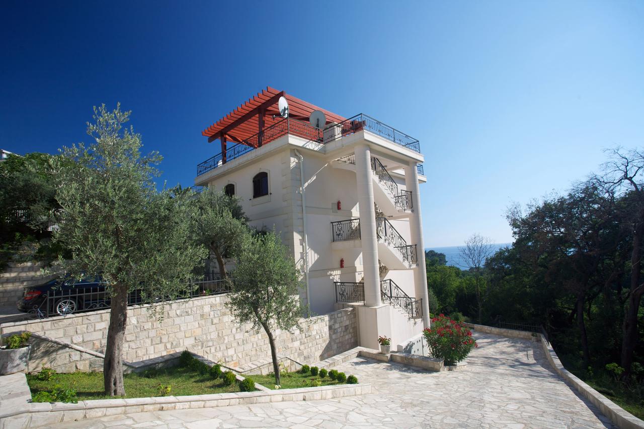 Dreistöckige Villa in Petrovac, Montenegro: Fassade mit offener Treppe, Dachterrasse und Meerblick.
