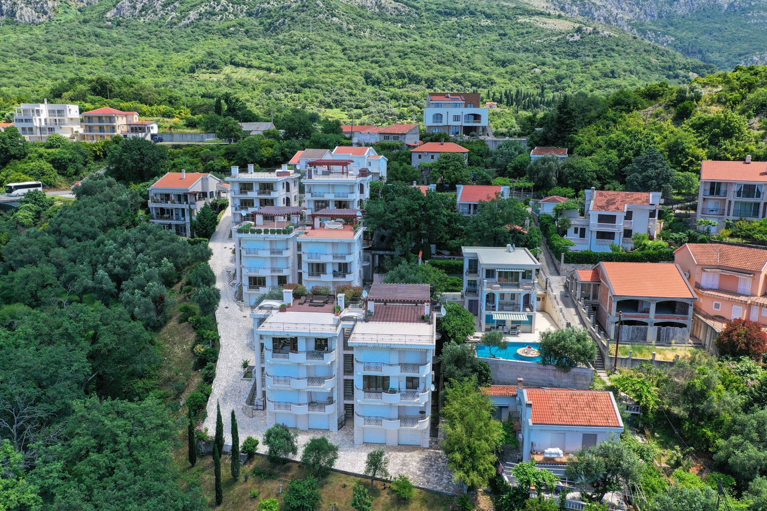 Luftaufnahme einer Wohnanlage mit Pool und Terrassen in Petrovac, Montenegro: moderne Wohnungen im Grünen.