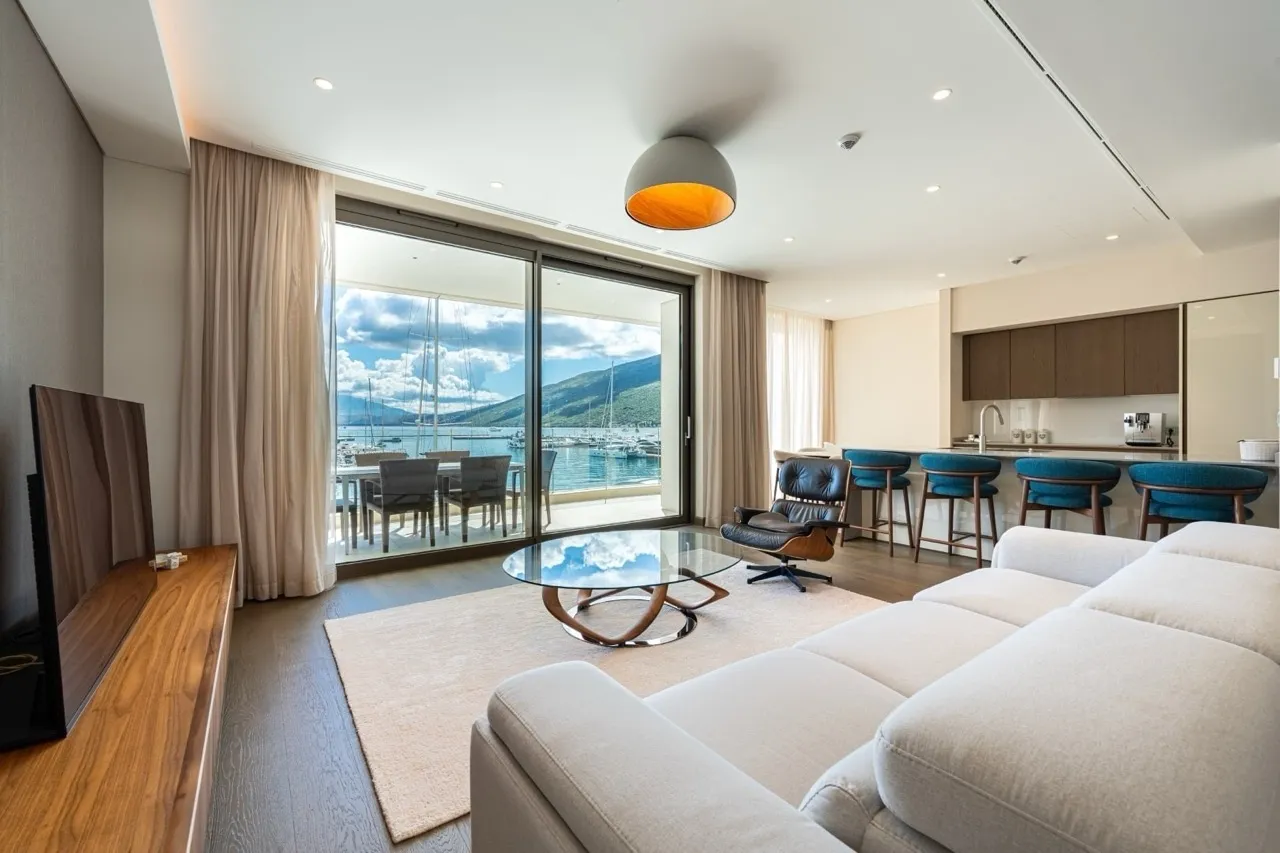 Wohnzimmer mit Blick auf den Yachthafen in Portonovi, Kumbor, Montenegro: moderne Möbel, Panoramafenster und offene Küche.