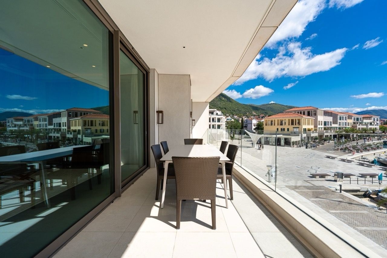Terrace with dining area in an apartment in Portonovi, Kumbor, Montenegro: panoramic view of the promenade and mountains.