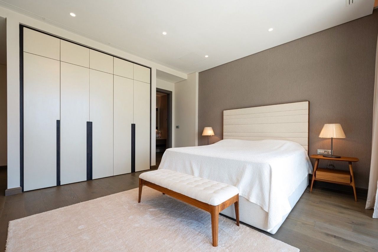 Modern bedroom in an apartment in Portonovi, Kumbor, Montenegro: double bed, built-in wardrobe, and parquet flooring.